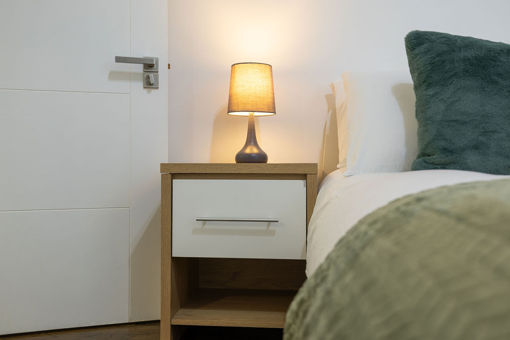 Bedside table and lamp in the three bedroom Reading apartment