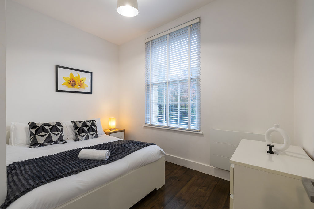 Second bedroom with a grey throw in the three bedroom Reading apartment