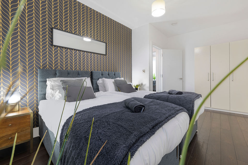 Main bedroom with a patterned feature wall in the two bedroom Reading apartment
