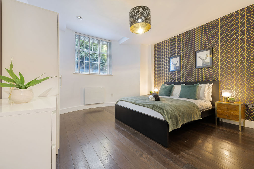 Second bedroom with a green bedspread in the two bedroom Reading apartment